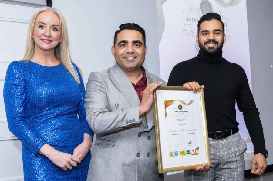 Two award winners holding their certificate with a host at the Asian Restaurant Awards