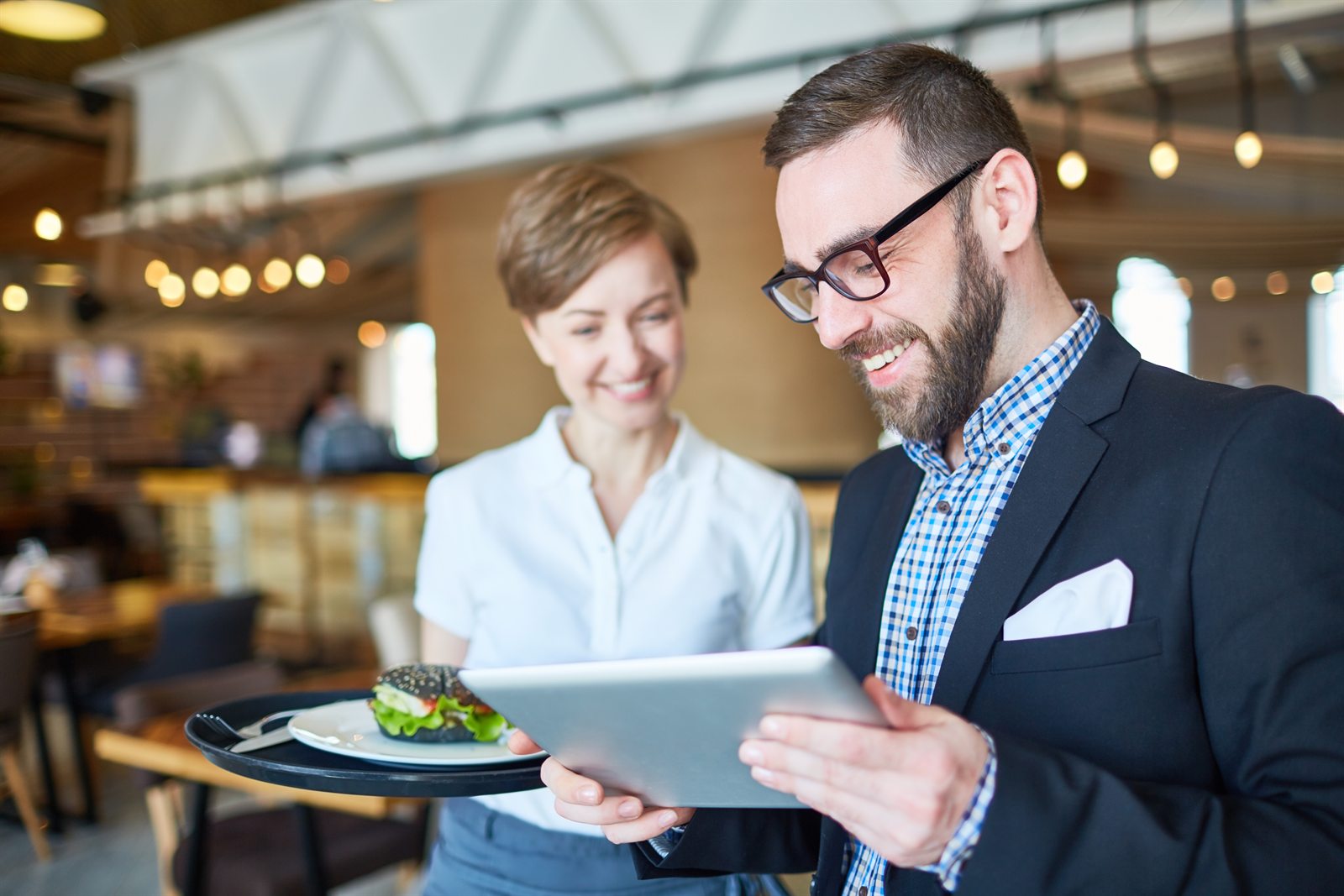 Manager and staff reviewing analytics on a tablet in a restaurant