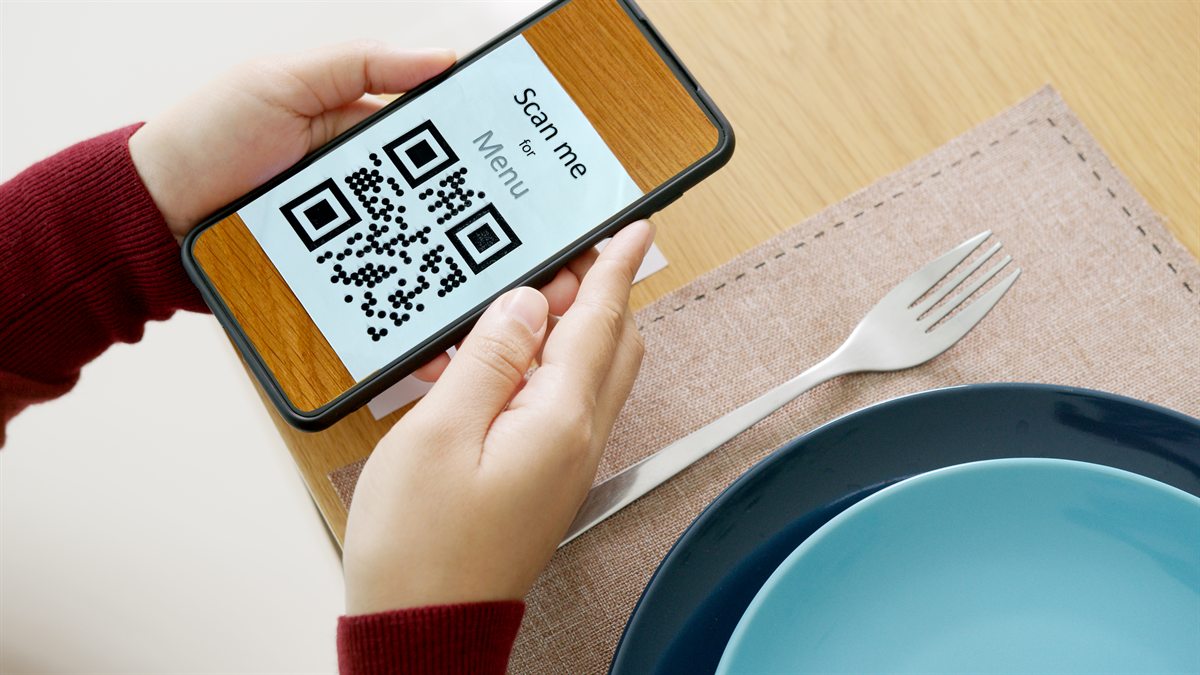 Customer scanning a Scan-me-for-menu QR code at a restaurant table